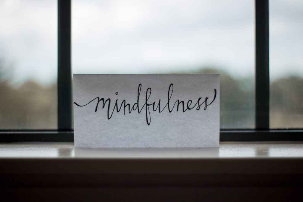 Eine Karte an einem Fenster lehnend mit der Aufschrift: "Mindfulness"
