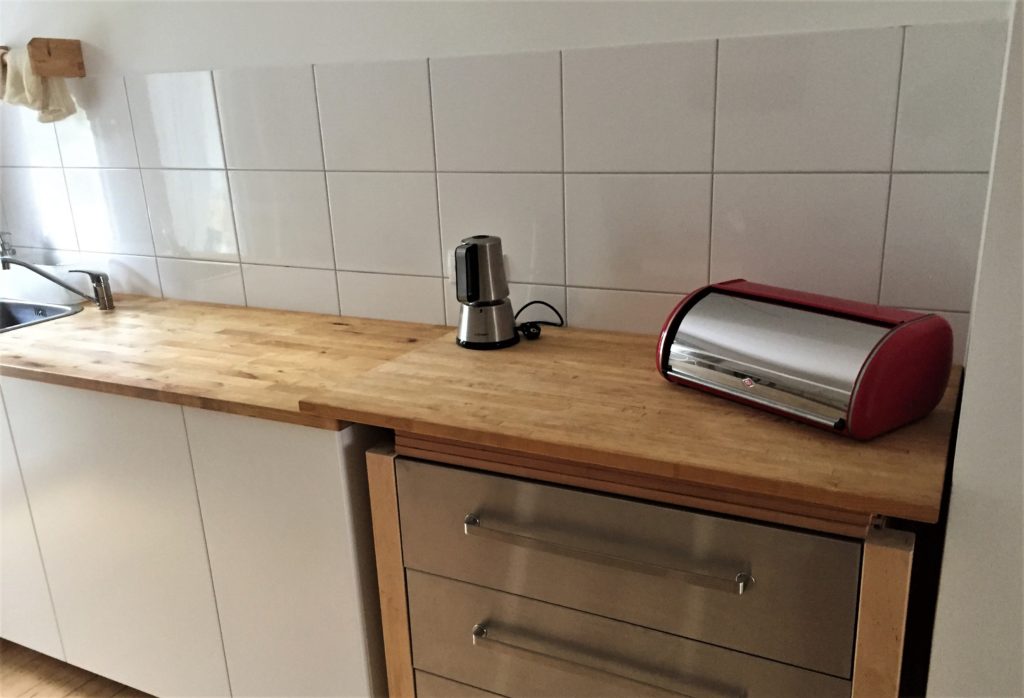 Küchenzeile links, rechts daneben ein Schubladenschrank mit lose aufliegender Arbeitsplatte