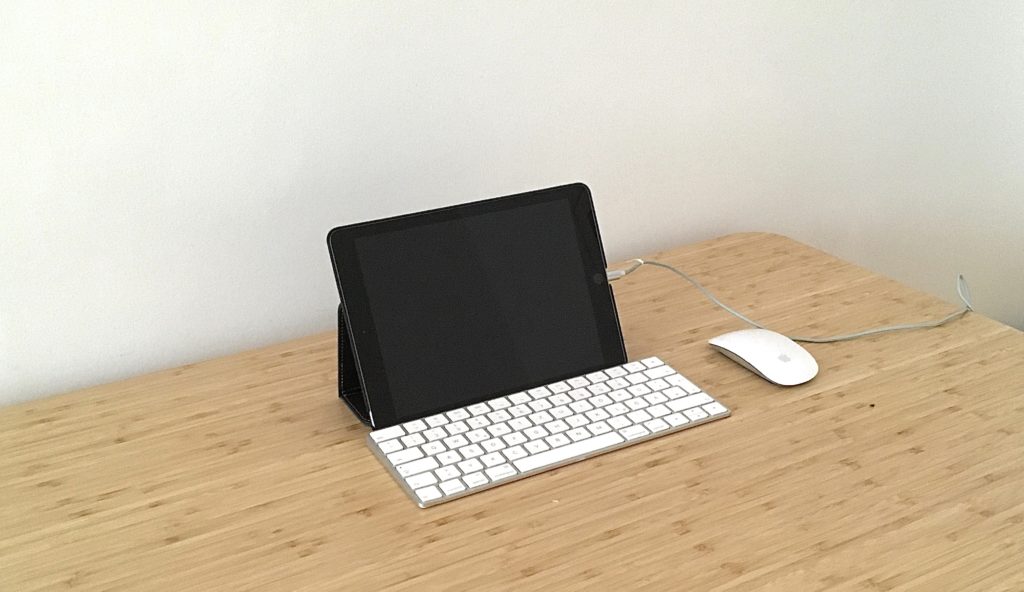 Tablet mit Tastatur und Maus auf einem Schreibtisch