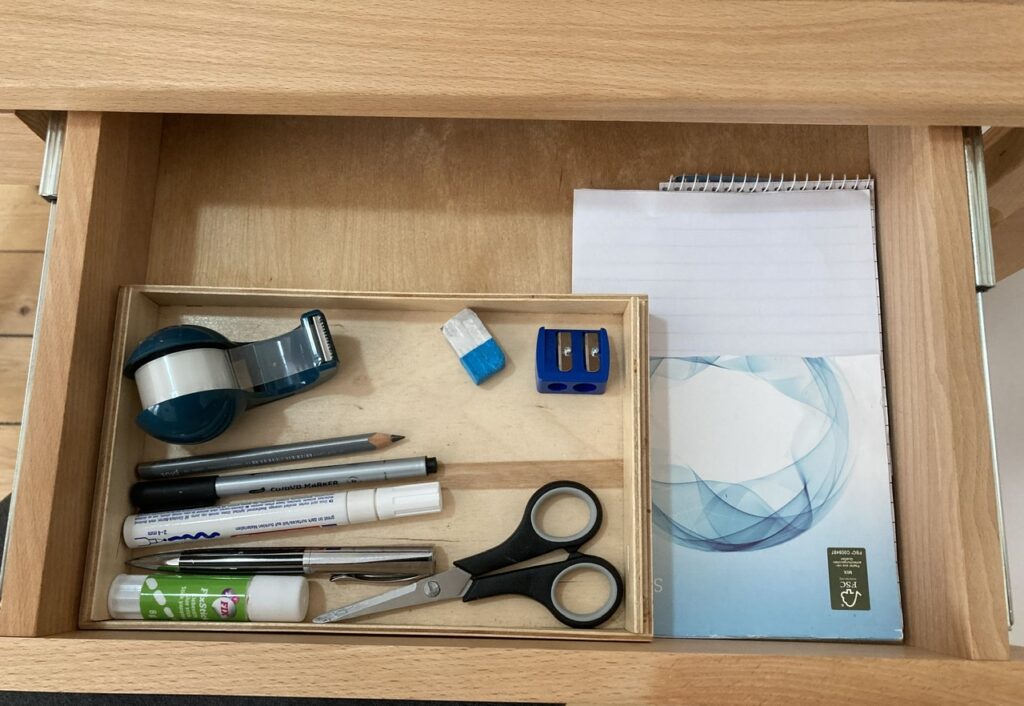 Schreibtischschublade mit 4 Stiften, Schere, Klebestift, Tesafilm, Anspitzer, Radiergummi und einem Notizblock