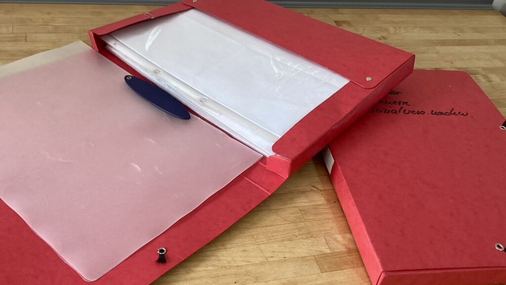 2 rote Aktensammler mit Unterlagen und Papieren, sowie ein Schnellhefter