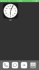 Homescreen iPhone: dunkelgrauer Hintergrund, oben links eine Uhr. Unten schwarz-weiße Icons